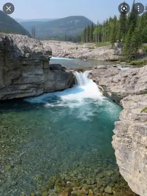 a waterfall in a river with rocks and water at Shanti Yurt with private hot tub in Bragg Creek in Bragg Creek
