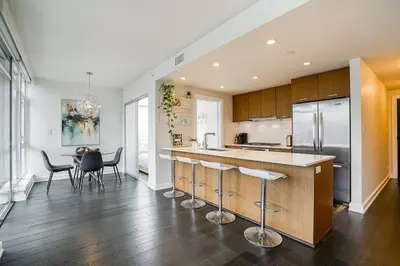 a kitchen with a island with bar stools at Modern Downtown Apartment with Water Views in Vancouver