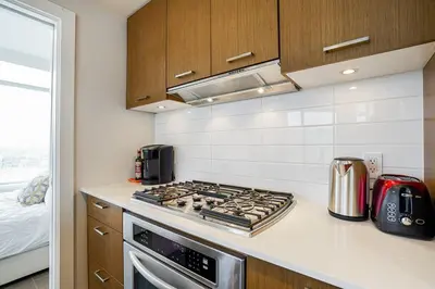 a kitchen with a stove top oven in a kitchen at Modern Downtown Apartment with Water Views in Vancouver