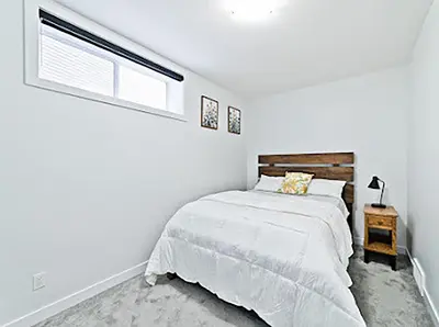 a white bedroom with a bed and a window at Cozy two bed apartment in Calgary