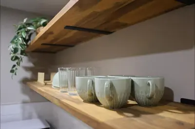 a row of bowls and glasses sitting on a shelf at Cozy 2BR Private Basement Suite, Free Parking, WiFi, 1 Hr to Banff, 20 Min to City in Calgary
