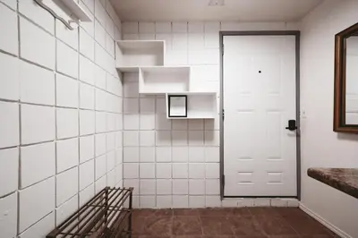 a white tiled hallway with a white door at The Cloud off 16th - 2bd 1 ba in Calgary