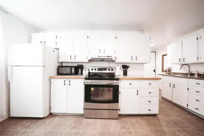 a kitchen with white appliances and white cabinets at The Cloud off 16th - 2bd 1 ba in Calgary