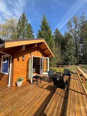 a wooden deck with chairs and a cabin at Gambier Lavender Lodge and Homestead in Gibsons