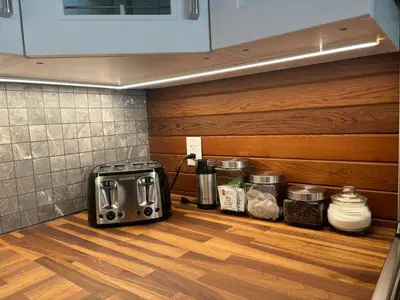 a kitchen counter with a toaster oven on a wooden floor at Gambier Lavender Lodge and Homestead in Gibsons