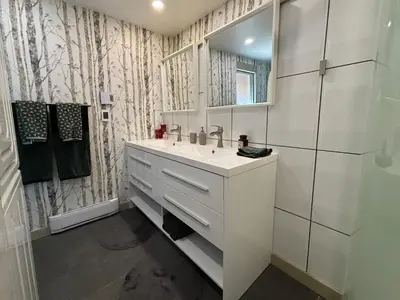 a white bathroom with a sink and a mirror at Gambier Lavender Lodge and Homestead in Gibsons