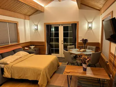 a bedroom with a bed and a table and a dining room at Gambier Lavender Lodge and Homestead in Gibsons