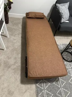 a brown bed sitting on the floor in a room at The Modern Nest-one bedroom basement suite in Calgary