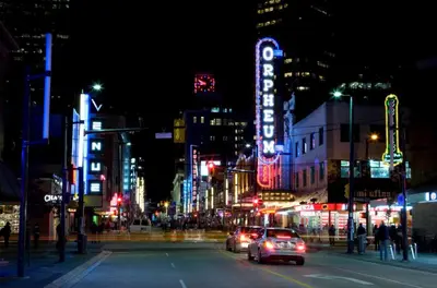 a city street at night with cars driving down the street at Gorgeous Unit in the Heart of Downtown in Vancouver