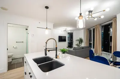 a kitchen with a sink and a living room at Gorgeous Downtown Unit with City Views in Vancouver