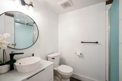 a white bathroom with a sink and a mirror at Gorgeous Downtown Unit with City Views in Vancouver