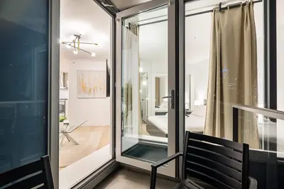 a room with a sliding glass door with a chair at Gorgeous Downtown Unit with City Views in Vancouver