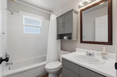 a bathroom with a sink and a toilet and a mirror at Hoodoo Hideout - 2BR House - Family Retreat - King Suite in Drumheller