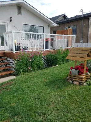 a wooden picnic table in the yard of a house at Hoodoo Hideout - 2BR House - Family Retreat - King Suite in Drumheller