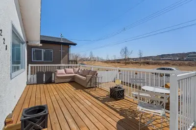 a deck with a couch and chairs on a house at Hoodoo Hideout - 2BR House - Family Retreat - King Suite in Drumheller
