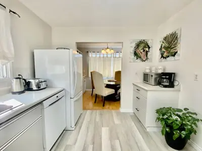 a kitchen with a white refrigerator and a table at Hoodoo Hideout - 2BR House - Family Retreat - King Suite in Drumheller