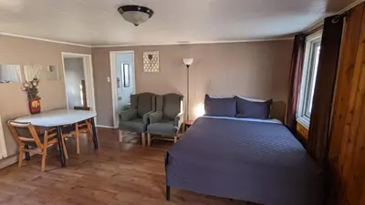 a bedroom with a bed and a table and a chair at Deerview Lodge & Cabins - Princeton BC in Princeton