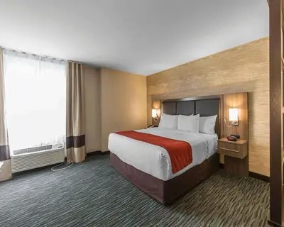 a hotel room with a bed and a large window at Comfort Inn & Suites Airport North in Calgary