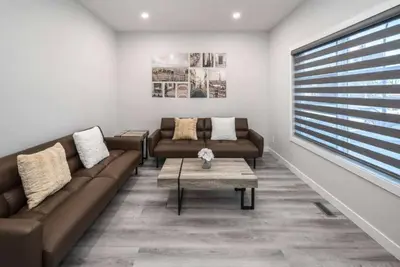 a living room with two couches and a coffee table at Group Stay, Sleeps 16! Near Downtown - 6BR Full Duplex, 2 Kitchens! FREE Banff Pass in Calgary