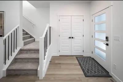 a hallway with a white door and stairs at Group Stay, Sleeps 16! Near Downtown - 6BR Full Duplex, 2 Kitchens! FREE Banff Pass in Calgary