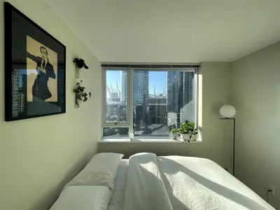 a bedroom with a bed and a window at Downtown Apartment in Vancouver