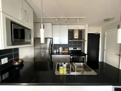 a kitchen with a sink and a stainless steel refrigerator at Downtown Apartment in Vancouver