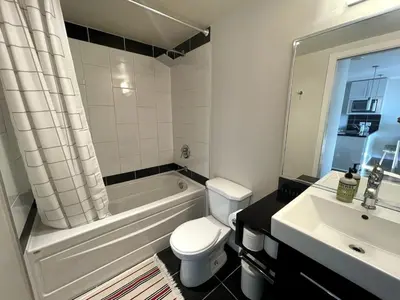 a bathroom with a tub and a toilet and a sink at Downtown Apartment in Vancouver