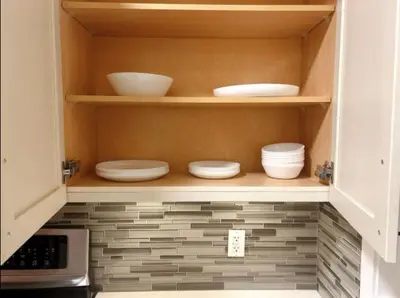 a kitchen cabinet with plates and bowls on shelves at Modern 3BR Near Airport & DT in Calgary