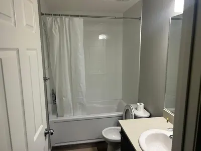 a bathroom with a shower and a toilet and a sink at Basement Suite Near Edmonton Airport YEG in Edmonton