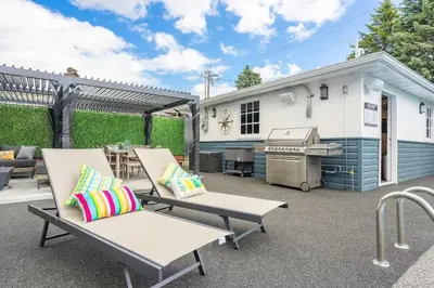 a patio with benches and a grill and a building at The Experience - Pool Hot Tub Theater Games Rm Pub in Calgary