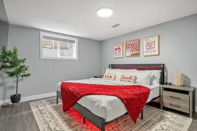 a bedroom with a bed with a red blanket on it at The Experience - Pool Hot Tub Theater Games Rm Pub in Calgary