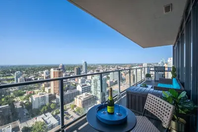 a balcony with a table and a view of a city at Executive Sky LUX - 2 BD 2BA Views Pool Patio & Gym in Calgary