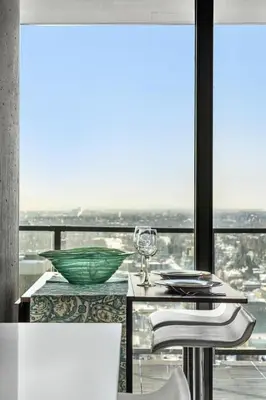 a dining room with a view of the city at Executive Sky LUX - 2 BD 2BA Views Pool Patio & Gym in Calgary
