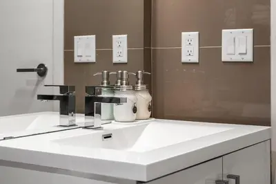 a bathroom with a white sink and a mirror at Executive Sky LUX - 2 BD 2BA Views Pool Patio & Gym in Calgary