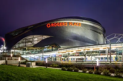 a large building with a sign on it at night at Eminence Sleek Studio City View in Edmonton