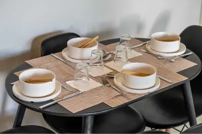 a table with four plates and glasses on it at Miso 2 BD - Skyline View Patio Gym Pool & AC in Calgary