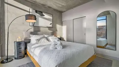 a bedroom with a large bed and a large mirror at Miso 2 BD - Skyline View Patio Gym Pool & AC in Calgary