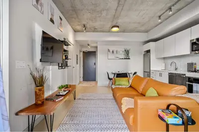 a living room with a couch and a table at Miso 2 BD - Skyline View Patio Gym Pool & AC in Calgary
