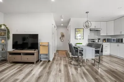 a kitchen with a dining table and a large television at Winston Suite 2BR 1BA - Carriage Suite with Garage in Calgary