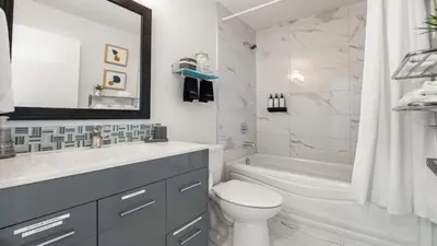 a white bathroom with a toilet and a sink at Winston Suite 2BR 1BA - Carriage Suite with Garage in Calgary