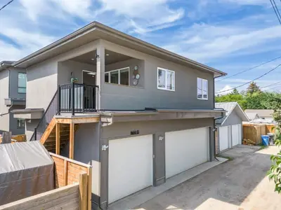 a house with two garage doors in a driveway at Winston Suite 2BR 1BA - Carriage Suite with Garage in Calgary