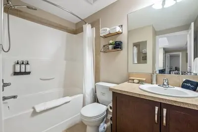 a bathroom with a sink and a toilet and a tub at The Grande 1BD 1BA - Full Kitchen Guest Suite in Calgary