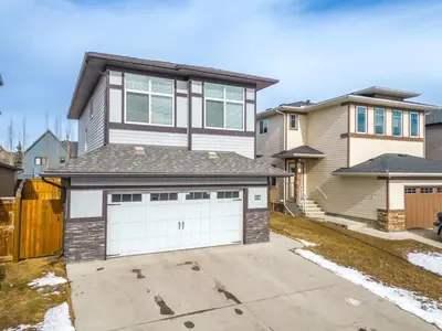 a house with two garage doors in a driveway at The Grande 1BD 1BA - Full Kitchen Guest Suite in Calgary