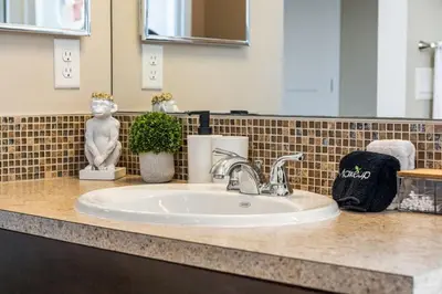 a bathroom counter with a sink and a mirror at The Venti - 3BD 2BA Yard Garage & Upper Suite in Calgary