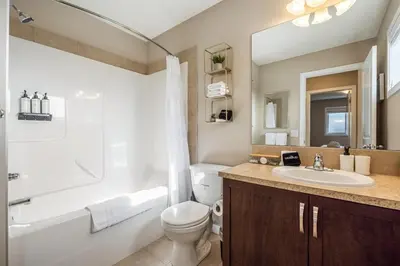 a bathroom with a white toilet and a sink at The Venti - 3BD 2BA Yard Garage & Upper Suite in Calgary