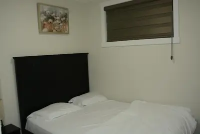 a bed with a black headboard and two pillows at Cozzy Cityscape & Airport Retreat in Calgary