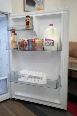 an open refrigerator with milk and eggs in it at Cozzy Cityscape & Airport Retreat in Calgary