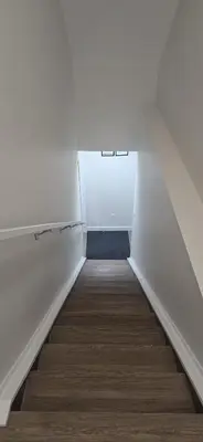a stairway with a white wall and a white door at Cozzy Cityscape & Airport Retreat in Calgary