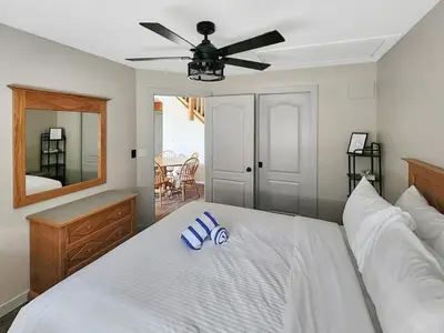 a bedroom with a white bed with a ceiling fan at Riverside Way by Fernie Lodging Company in Fernie