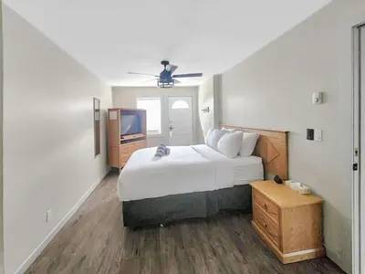 a bedroom with a large bed and a tv at Riverside Way by Fernie Lodging Company in Fernie